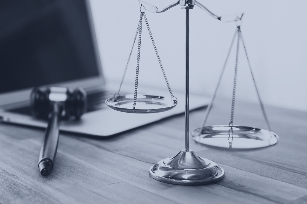 Golden balanced scale and gavel on desk with laptop in law office background, should I contact a lawyer after car accident