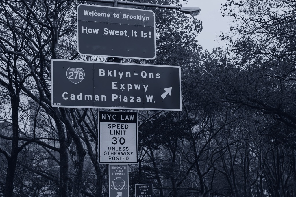 Several traffic signs at one of the Brooklyn, New York entrances