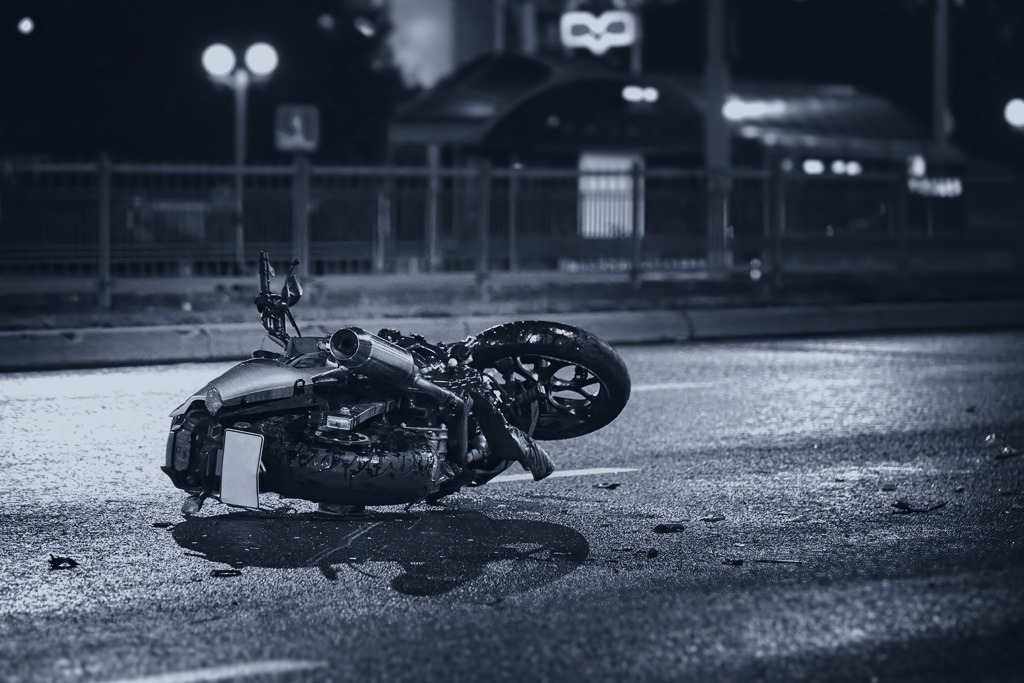 Queens motorcycle accident lawyer, motorcycle lying on asphalt after a road accident at night